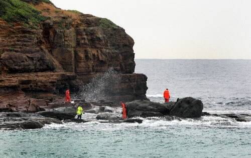 SES officers scour rocks near the lighthouse.Picture: ORLANDO CHIODO