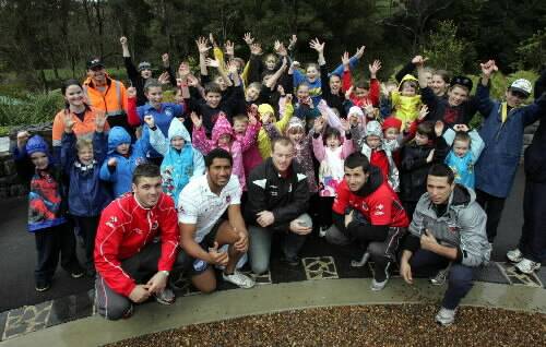 NSW centre Beau Scott (centre), along with Dragons youngsters Simon Maslanka, Kalifa Fai Fai Loa, Jake Marketo and Nathan Rose, joined students from Mt Kembla Public School plant trees. Picture: ANDY ZAKELI