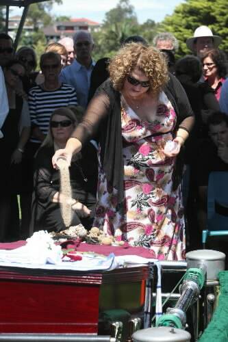 Daughter Narelle Tutton pours sand from Port Elliot over the casket during the service.