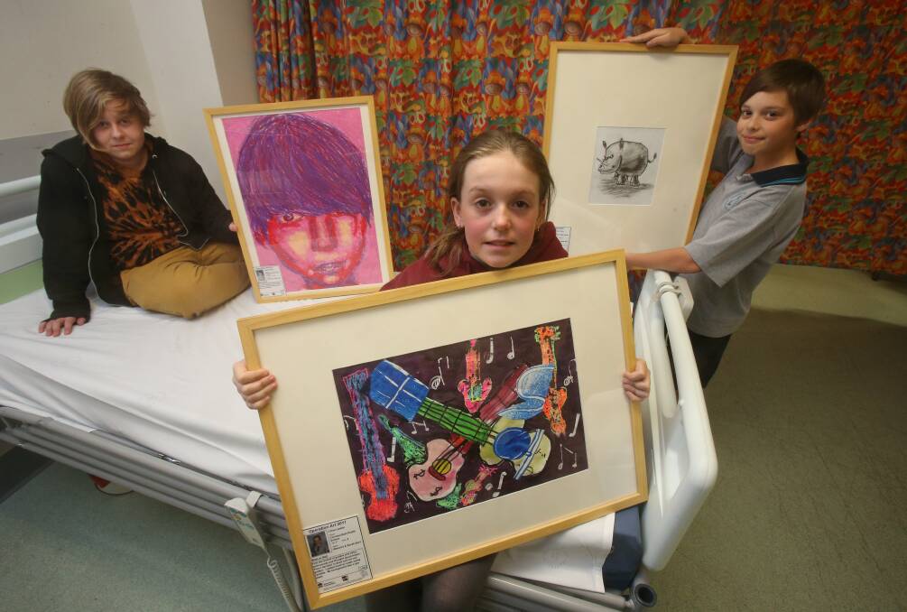 Young artists Riley, 17, Chloe, 9, and Zachary, 12, show off their works. Picture: ROBERT PEET