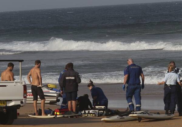 Lifeguards, ambulance paramedics and police attempt to save the life of Paolo Lucchini who was pulled from the surf at Puckeys Estate on Thursday. Picture: KEN ROBERTSON