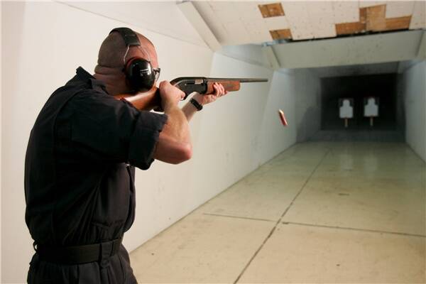 A police officer test fires oneo fh te guns allegedly seized in August.