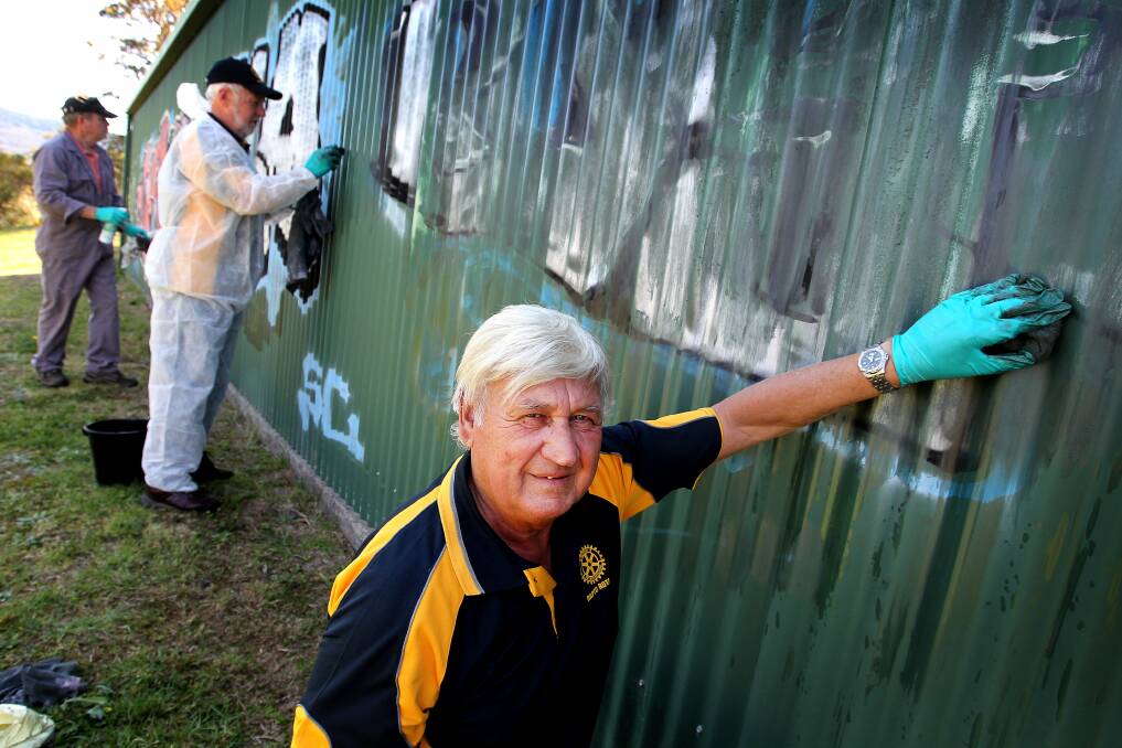 Mick Chamberlain, Barry Hemley and John Greeshaw help scrub graffiti from a building at Kembla Grange for Graffiti Removal Day. Picture: SYLVIA LIBER