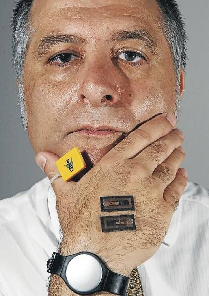 Dr MG Michael wears a radio-frequency identification wristband, stick tag and button. Picture: GREG TOTMAN