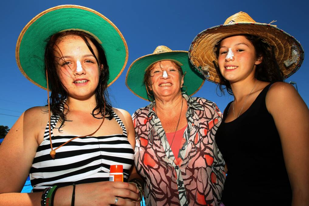 Naomi, 14, Shellharbour Mayor Marianne Saliba and Tiarn protect themselves. Picture: GREG TOTMAN