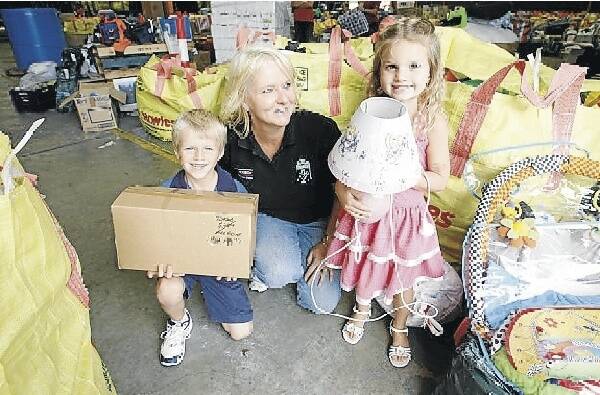 Jack and Lilly McDonald, 6 and 4, give their donations to Cherylanne Crist. Picture: DAVE TEASE