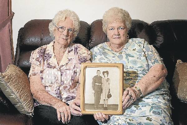 Kathleen Gould (left) and sister Miriam Harrison with a photo of their late brother-in-law Cyril Richardson and sister Betty on their wedding day.Picture: ADAM McLEAN