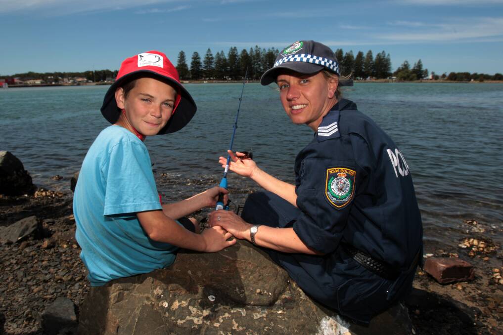 Jerrone, 11, and Lake Illawarra Sergeant Danielle Rebbeck cast a line at Reddell Reserve. Picture: GREG TOTMAN