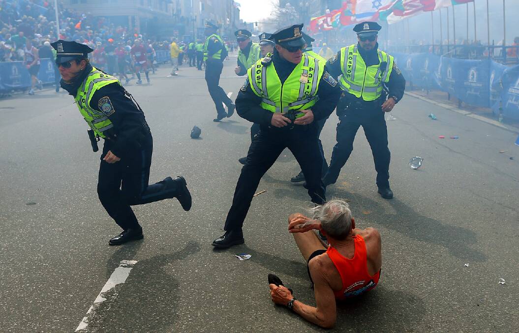 Bill Iffrig, 78, lies on the ground as police officers react to the second explosion at the finish line.Picture: AP