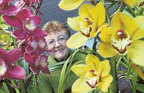  Kanahooka's Helen Williams with two of the orchid varieties displayed at the show. Pictures: KEN ROBERTSON 