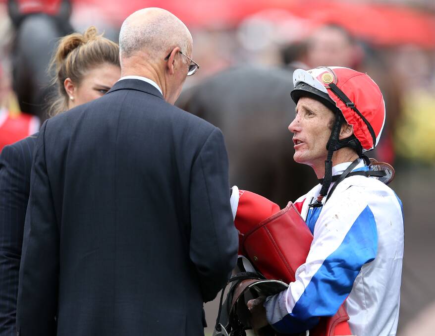 Jockey of Americain, Damien Oliver, talks to trainer Alain de Royer Dupre after the Melbourne Cup race. Picture: GETTY IMAGES