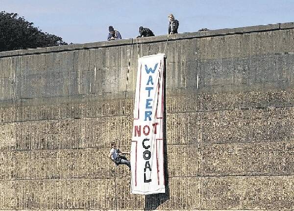 Climate Change activists unfurl their banner at Woronora Dam wall. Picture: DAMIAN BAKER