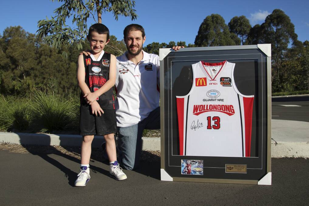 Jackson Paulic, 8, with Hawks player Rhys Martin and the framed shirt that Jackson bought.