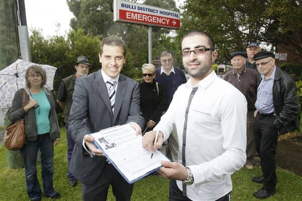  David Akele adds the 10,000th signature to a petition organised by Member for Keira Ryan Park (left) calling for an upgrade to Bulli Hospital. Picture: DAVE TEASE