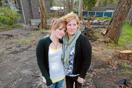 April Lee with her mother Annette Wood stands on the vacant land in Nowra from where Mrs Lee’s three-bedroom kit home was stolen on Saturday.