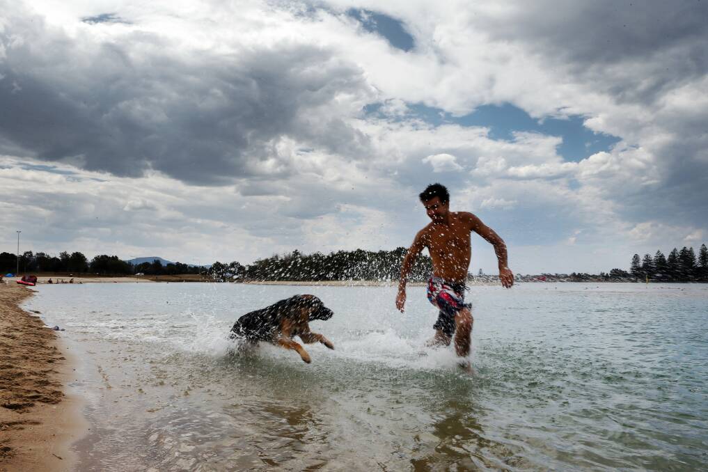 Chris Onley with his German shepherd Jax at Lake Illawarra as the cool change came through. Picture: ADAM McLEAN