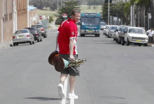 The Hawks' Mat Campbell walks down Harbour St yesterday, with the NBL 2000/2001 trophy. Like several Hawks, he faces an uncertain future. Picture: DAVE TEASE