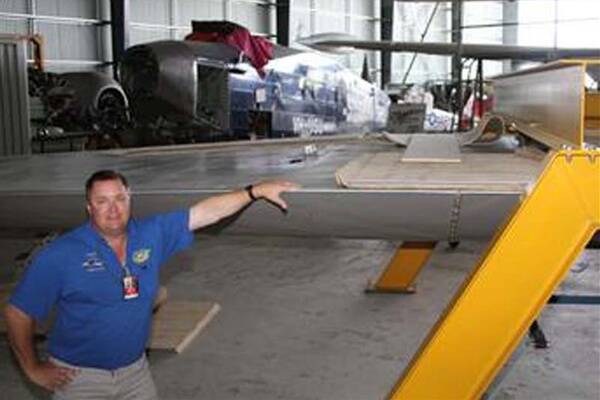 Restoration project manager Geoff Timms with pieces of the Southern Cross replica at Illawarra Regional Airport. Picture: GREG ELLIS