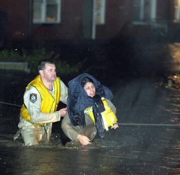 Police Rescue officer Senior Constable Gary Storey rescues Lina Cappetta from rising flood waters on Pioneer Rd Towradgi in 1998.