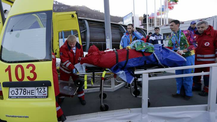 Broken legs ... A track worker is loaded into an ambulance after he was injured when a forerunner bobsled hit him before the start of the men's two-man bobsled training. Photo: AP Photo