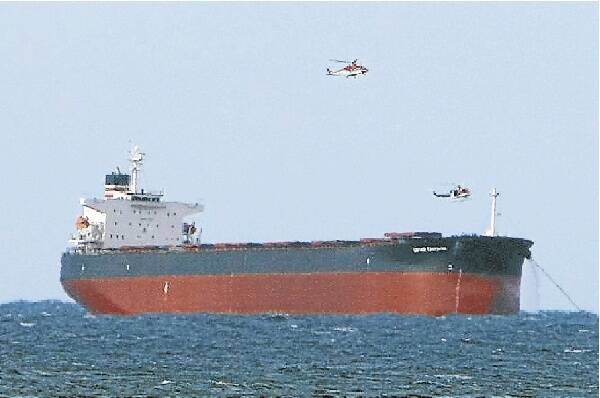 A rescue chopper hovers over a bulk carrier where two sailors were badly hurt. Picture: KEN ROBERTSON