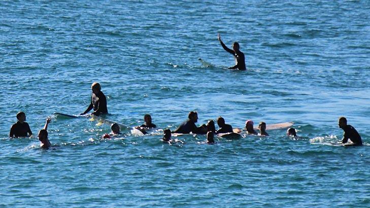 THE AFTERMATH ... surfers rush to the aid of the victim, Bishan Rajapakse. Photo: Rory Edwards / Fairfax Media