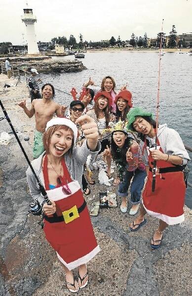 Jessica Li (front) and friends, from inner Sydney, fished for their Christmas lunch off the breakwall at Wollongong Harbour yesterday. Picture: KIRK GILMOUR