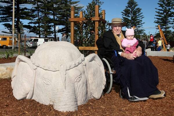 Don Gray OAM and his great-granddaughter Katinke Biffin next to the symbolic elephant head, a nod to a colourful slice of Thirroul history in which an elephant escaped from a visiting circus and became stuck in the nearby lagoon. Pictures: MELANIE RUSSELL 