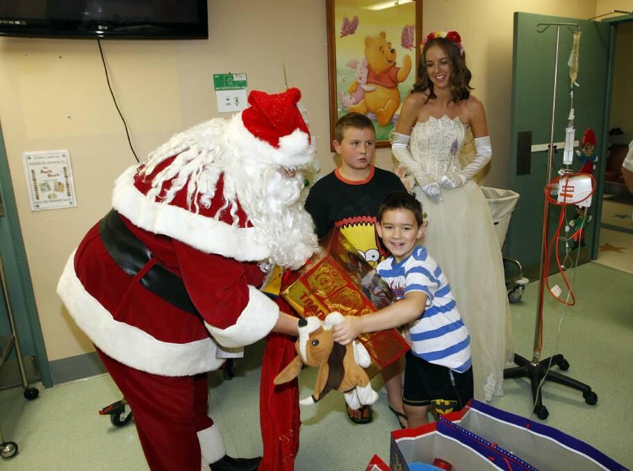 Gabriel Angeleski of Warrawong receives a gift from Santa and the Kidzwish Fairy. Picture ANDY ZAKELI