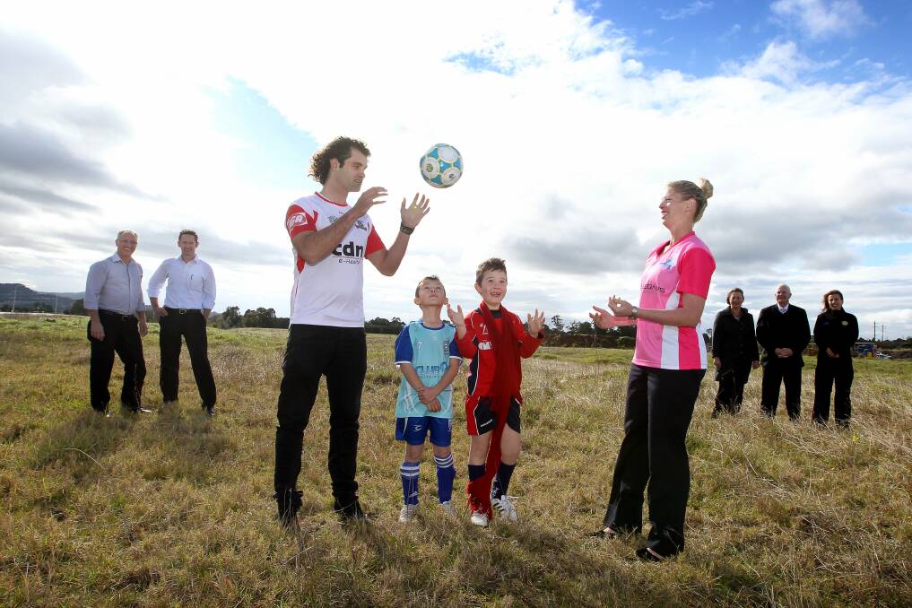 Wolves player Jacob Timpano , with Brandon De Gabriele and Luke Balliano and Wollongong Stingrays player Sarah Gollop (front) at the proposed site for the West Dapto 'Home of Dreams'. Picture SYLVIA LIBER