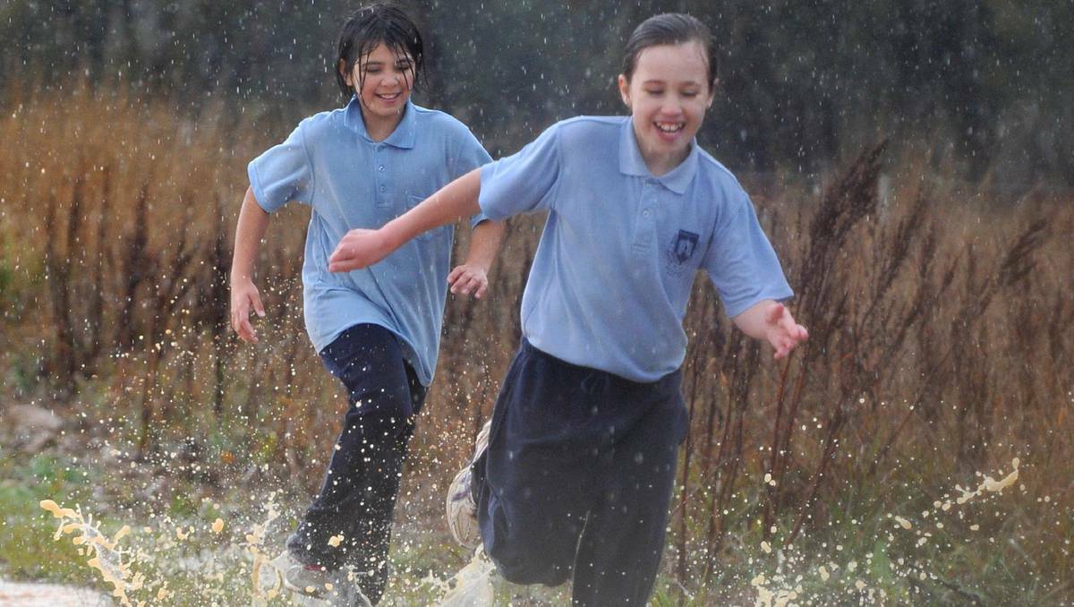 Tahlia Frost-Hocking and Claudia Morris of Ashmont Public School race through the wet conditions at the PSSA Cross Country at Ladysmith. Picture: Michael Frogley (DAILY ADVERTISER) 