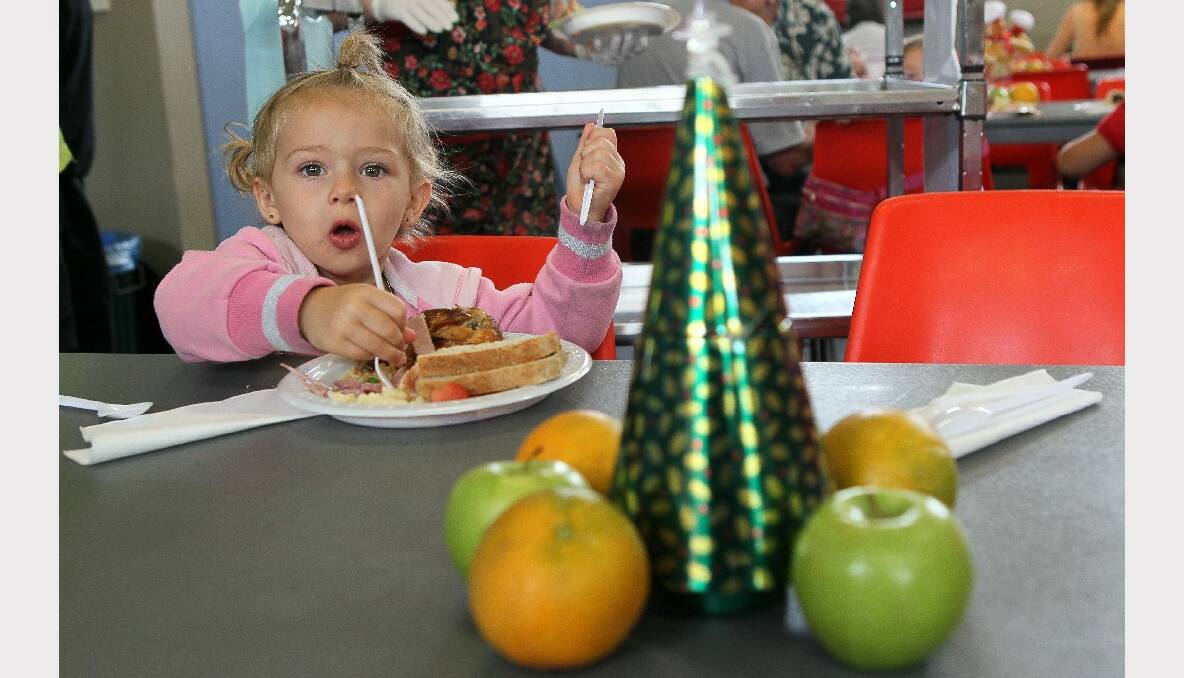 Three-year-old Chardae enjoys her meal at the Warrawong Community Centre Christmas lunch. PICTURE: KIRK GILMOUR