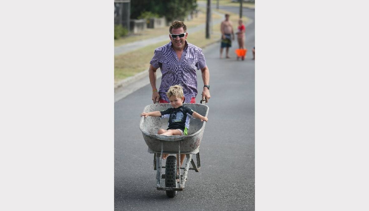 Sydney's David McIlwaine pushes his son Toby, 4, in the brickies race at Kiama. Picture: Dylan Robinson