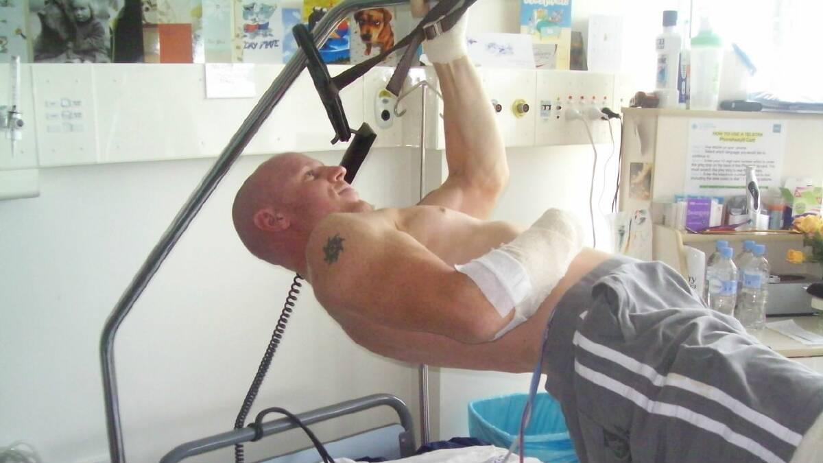 Shark attack victim Paul de Gelder performs one arm chin-ups from his hospital bed.