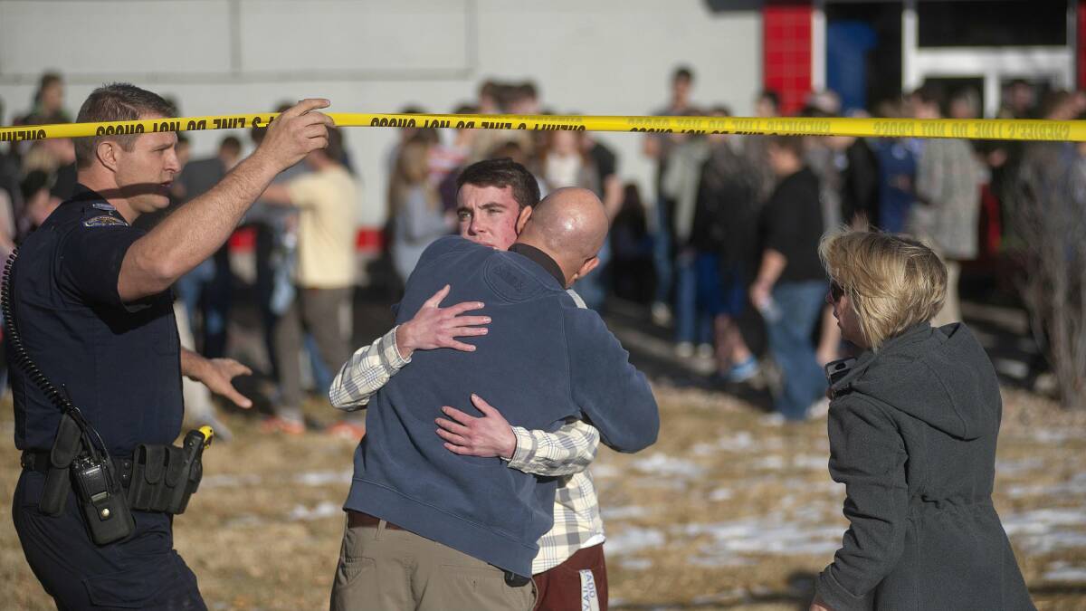 students gather and reunite with their parents at a fast food business across the road from Arapahoe High School, after a student opened fire, wounding two classmates before killing himself. Picture: REUTERS