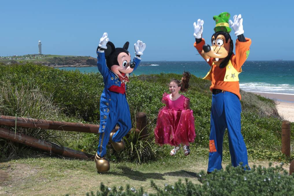 Seven-year-old Bridie Farrell meets Mickey Mouse and Goofy. Picture: ADAM McLEAN