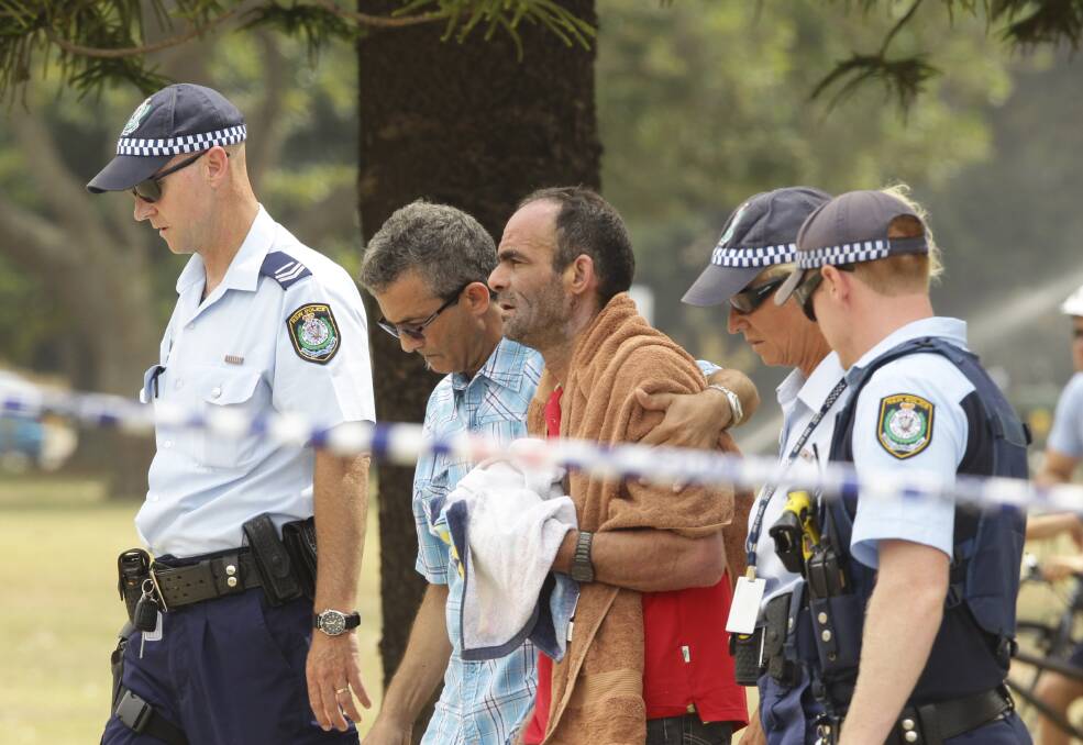 Police escort the father (3rd from left) of 5 year old Ayman Ksebe from the beach near the George's River sailing club after informing him that his son's body has been recovered. Picture: KATE GERAGHTY