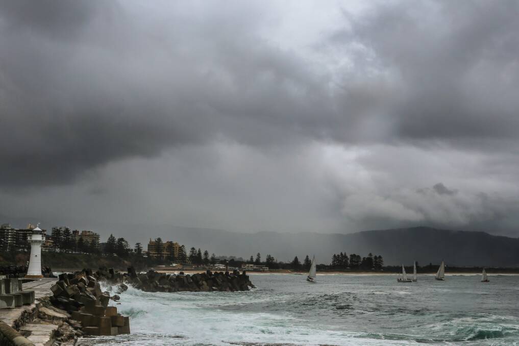 Yachts sail across Wollongong Harbour as the rain moves in on Sunday. Picture: ADAM McLEAN