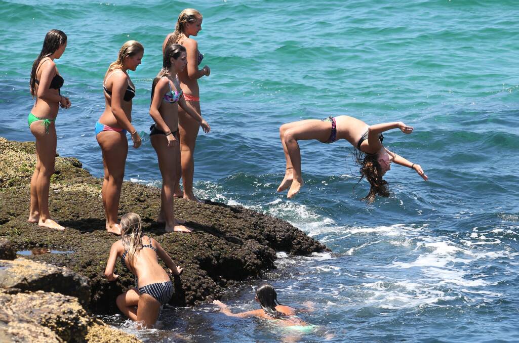 Summer weather had holidaymakers turning backflips at Wollongong City Beach yesterday. Picture: KIRK GILMOUR