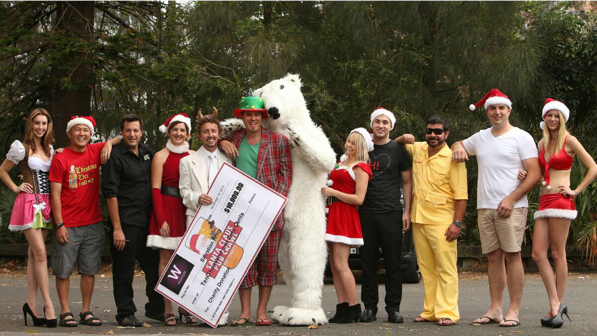 Participants in the Santa Pub Crawl, including organiser Neil Webster, fifth from left, with a $10,000 cheque. Picture: KIRK GILMOUR