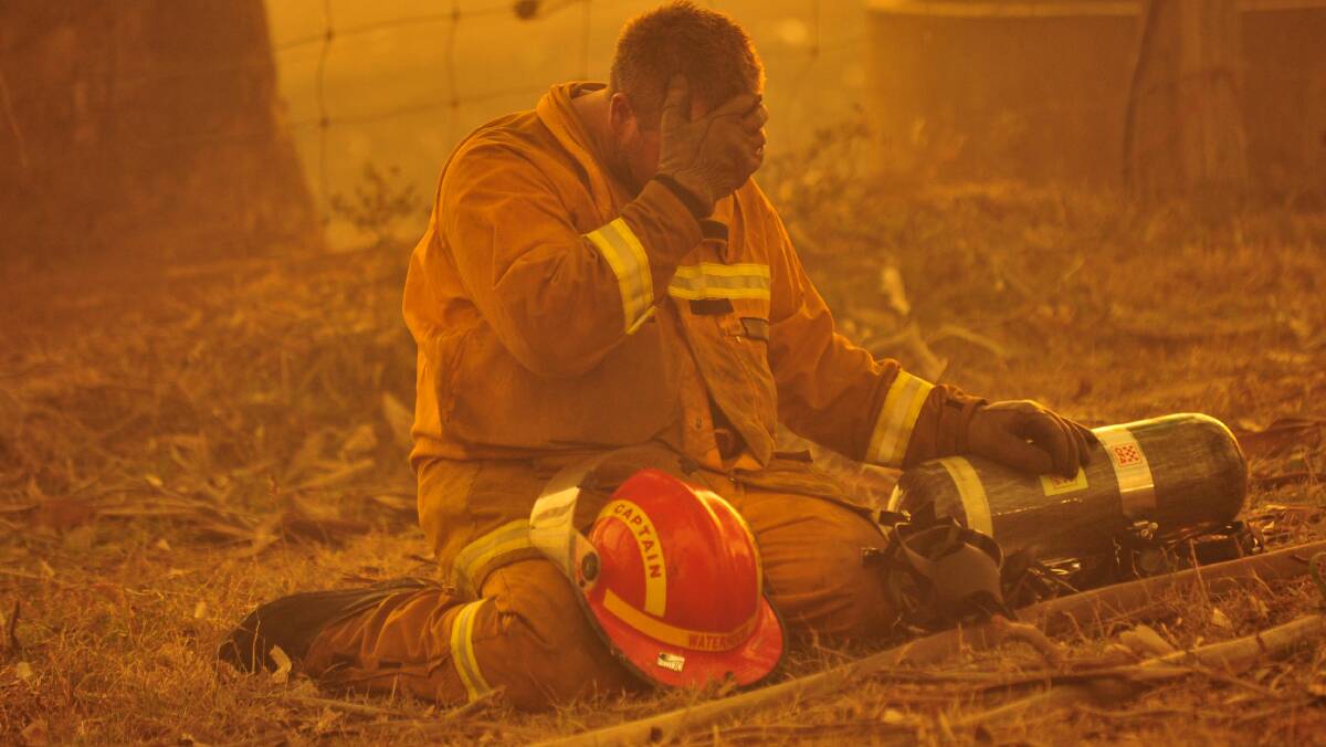 A firefighter in despair during the Black Saturday bushfiresin Victoria in 2009. Picture: JASON SOUTH
