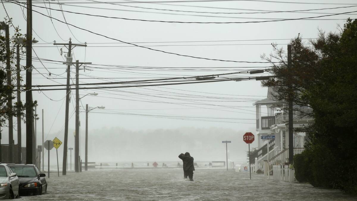 A man wades through water in Maryland. Picture: REUTERS