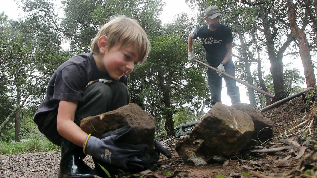 Luke White, 6, and his dad, Matt White help clean up Mt Keira lookout. Picture: ROBERT PEET
