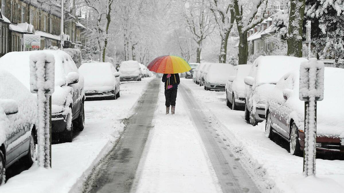 A girl walks along a snow-covered street in northern England. Picture: REUTERS