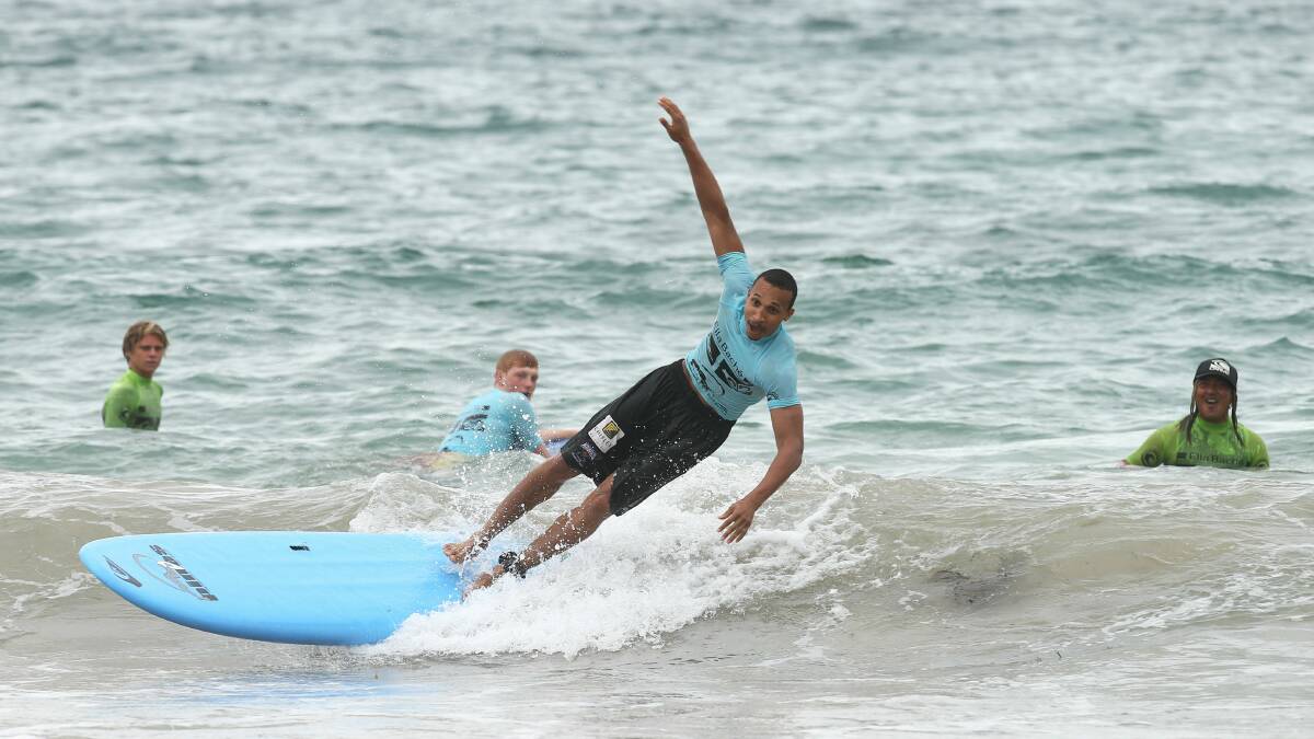 Wollongong Hawks guard Adris Deleon gets some surfing tips from Pines Surf School at North Wollongong Beach yesterday. Pictures: KIRK GILMOUR
