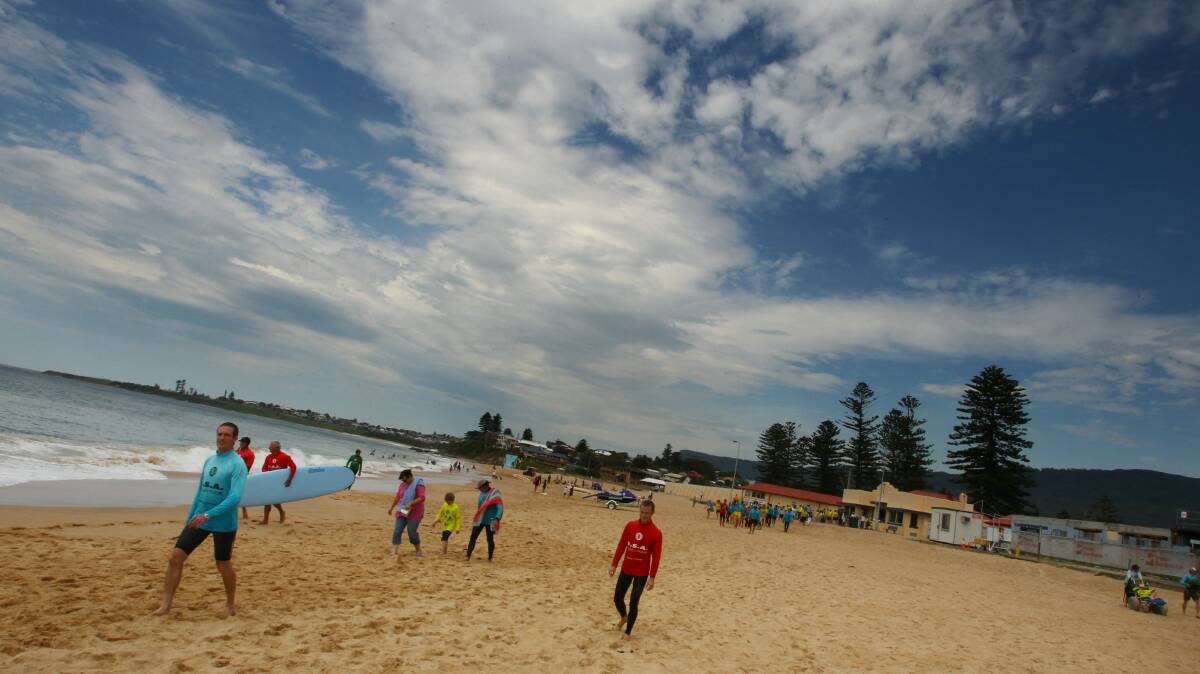 Beachgoers enjoy the first day of summer at Thirroul Beach on Saturday. Picture: KEN ROBERTSON