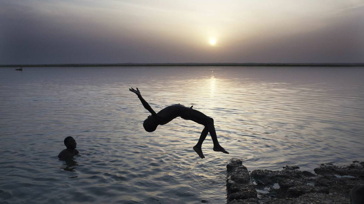 A boy does a backflip into a river in Mali. Picture: REUTERS