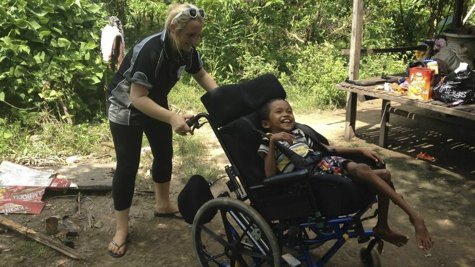 Cambodian boy Ratha, 11, enjoying a wheelchair, donated by Illawarra charities  and delivered by Shellharbour woman Faye Webb. 