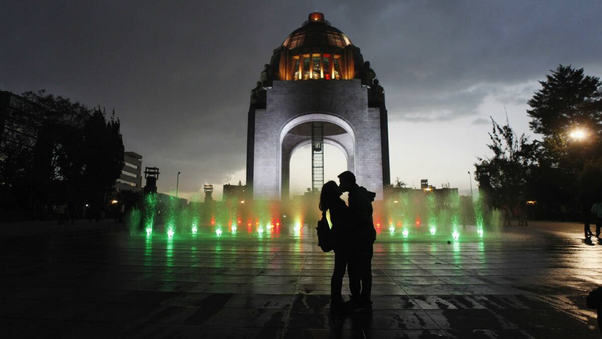 A couple embrace in front of the Revolucion monument in Mexico City. Picture: REUTERS