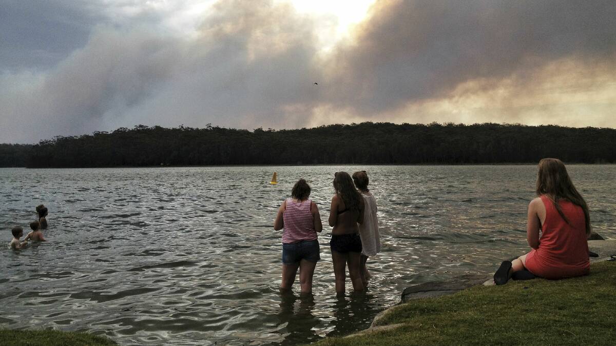 People watch the Wandandian fire burn from Lake Conjola. Picture: DYLAN ROBINSON